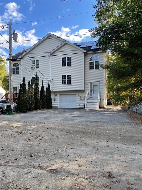 view of front of property featuring solar panels and a garage