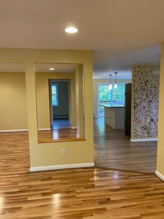 hall featuring a baseboard radiator and light hardwood / wood-style floors