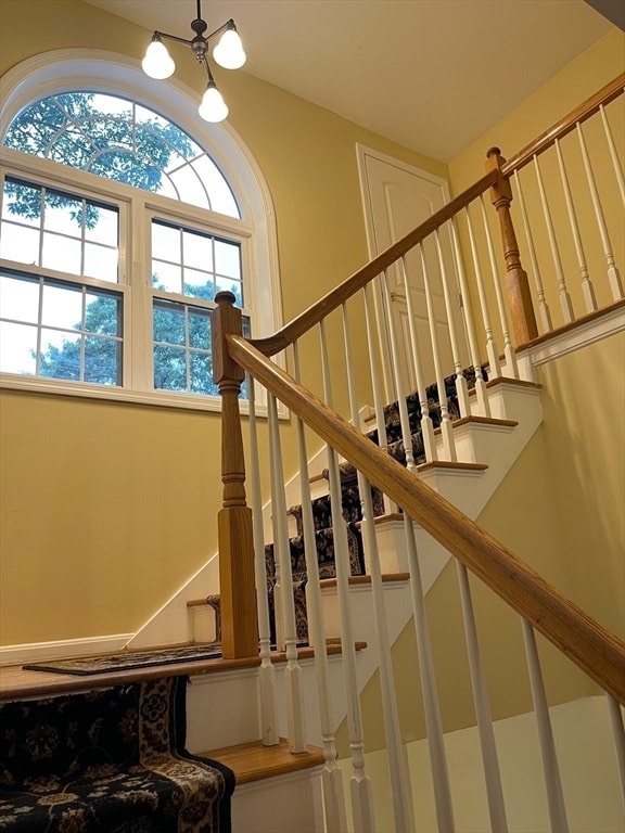 stairs featuring a notable chandelier