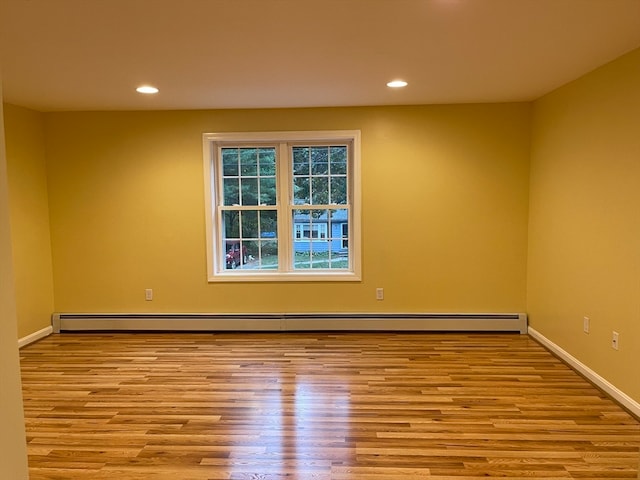 unfurnished room with light hardwood / wood-style floors and a baseboard radiator