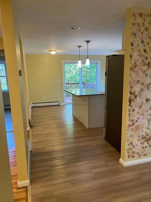 hall featuring baseboard heating and light hardwood / wood-style flooring