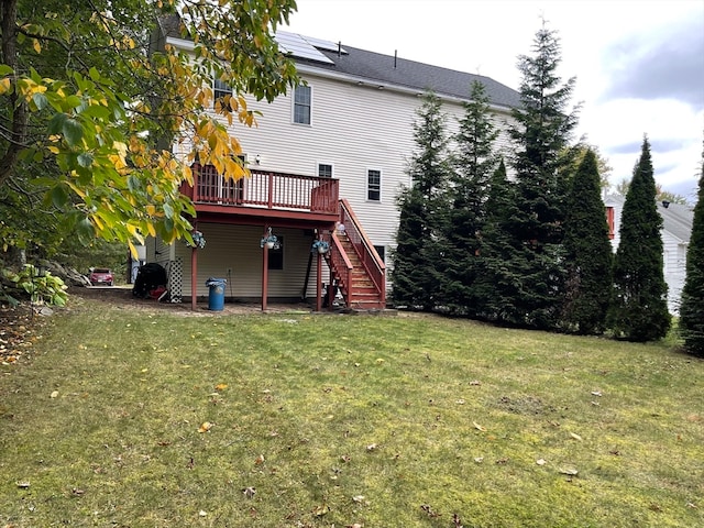 back of house featuring a deck and a lawn