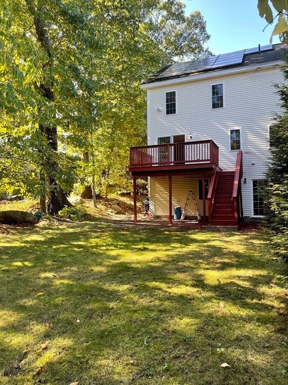 back of house with a wooden deck and a yard