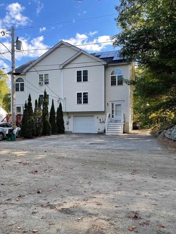 view of front of home featuring a garage and solar panels