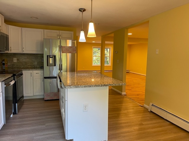 kitchen with baseboard heating, decorative light fixtures, stainless steel appliances, and white cabinets