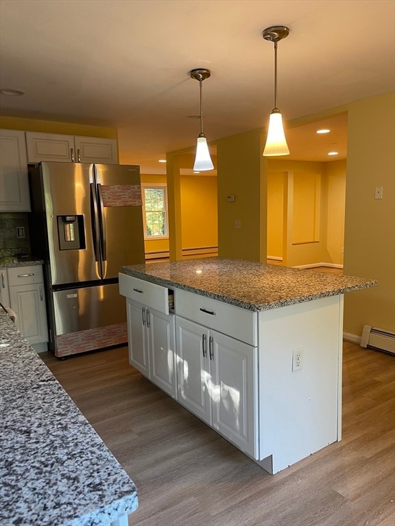 kitchen with white cabinets, light hardwood / wood-style floors, and stainless steel fridge with ice dispenser