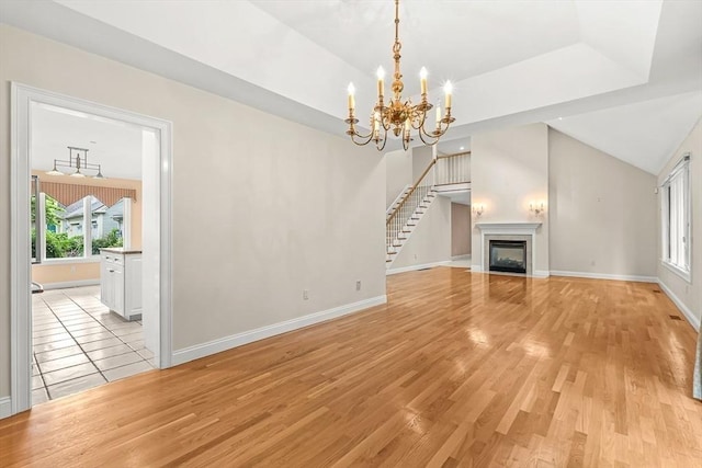 1205 Magnolia Dr Unit 1205, Wayland, MA 01778 - unfurnished living room with light wood-style floors, baseboards, a chandelier, and vaulted ceiling