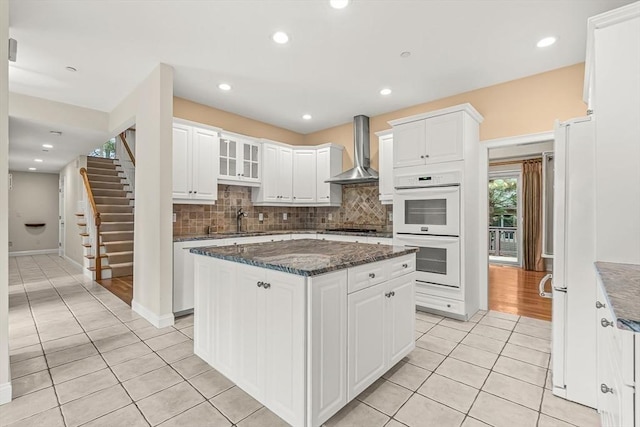 1205 Magnolia Dr Unit 1205, Wayland, MA 01778 - kitchen with wall chimney exhaust hood, white double oven, light tile patterned flooring, white cabinets, and recessed lighting