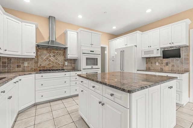 1205 Magnolia Dr Unit 1205, Wayland, MA 01778 - kitchen featuring wall chimney exhaust hood, high end fridge, light tile patterned floors, white cabinetry, and recessed lighting