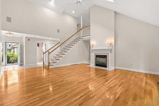1205 Magnolia Dr Unit 1205, Wayland, MA 01778 - unfurnished living room featuring high vaulted ceiling, stairway, ceiling fan, light wood-style floors, and baseboards