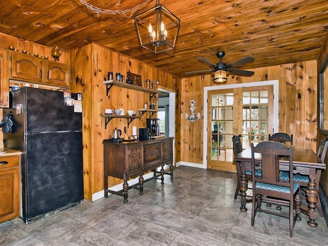 dining space with wood walls, french doors, wood ceiling, and ceiling fan with notable chandelier