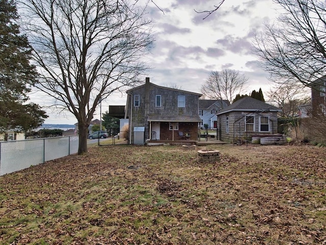 rear view of property with a fire pit