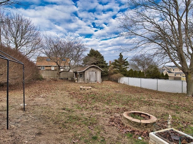 view of yard featuring a shed and an outdoor fire pit