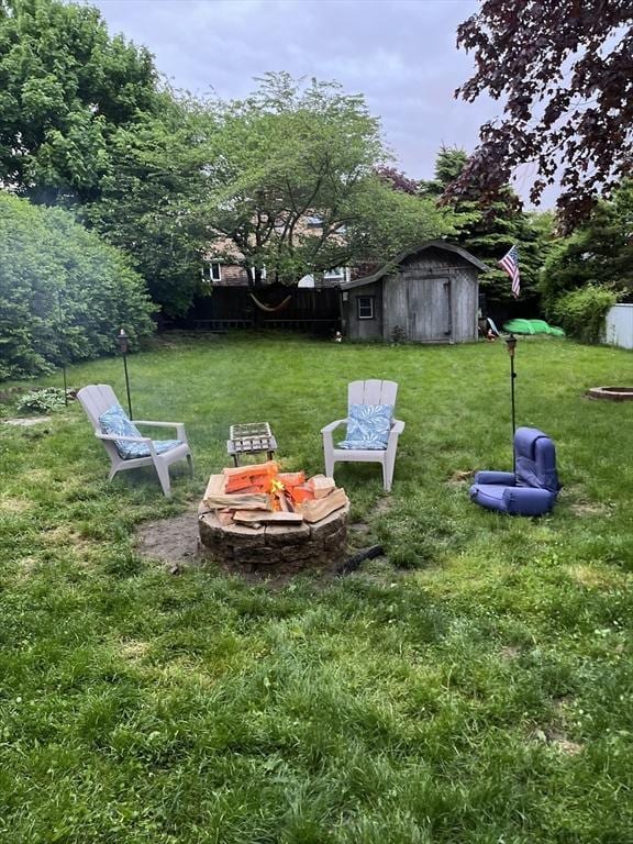 view of yard with a shed and a fire pit