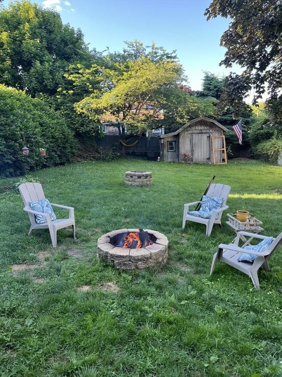 view of yard featuring a storage unit and an outdoor fire pit