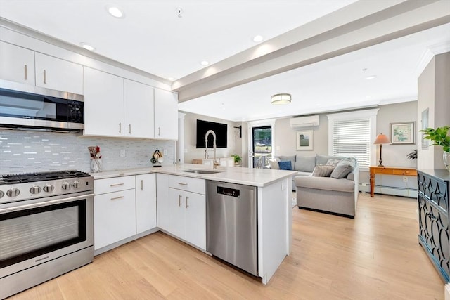 600 Shirley St Unit 3, Winthrop, MA 02152 - kitchen featuring stainless steel appliances, a wall unit AC, a sink, open floor plan, and a peninsula