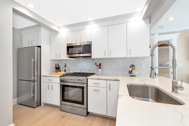 600 Shirley St Unit 3, Winthrop, MA 02152 - kitchen with stainless steel appliances, a sink, light wood-type flooring, tasteful backsplash, and recessed lighting