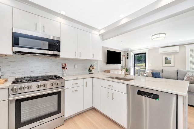 600 Shirley St Unit 3, Winthrop, MA 02152 - kitchen with appliances with stainless steel finishes, open floor plan, a wall mounted air conditioner, a peninsula, and a sink