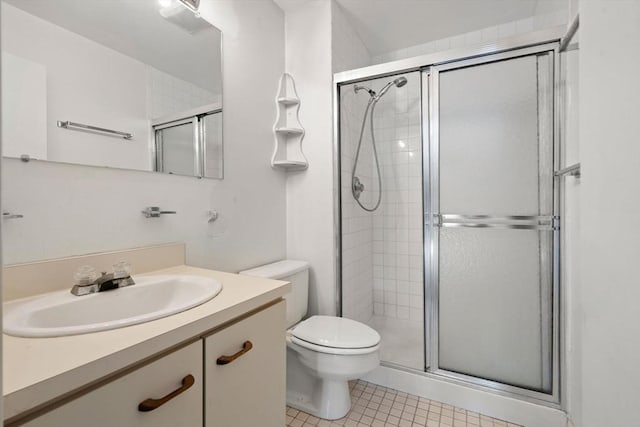 bathroom featuring vanity, tile patterned flooring, toilet, and a shower with shower door