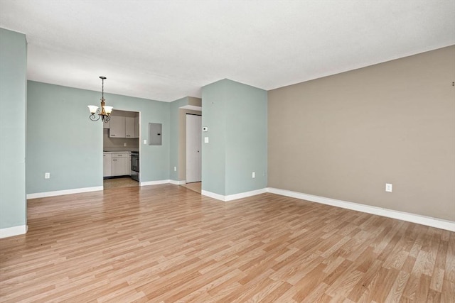 unfurnished living room with electric panel, light hardwood / wood-style floors, and a chandelier