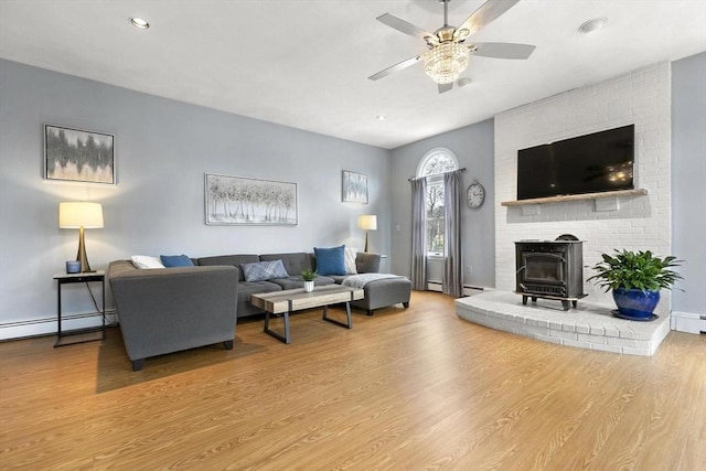 living room with a baseboard radiator, wood finished floors, and a ceiling fan