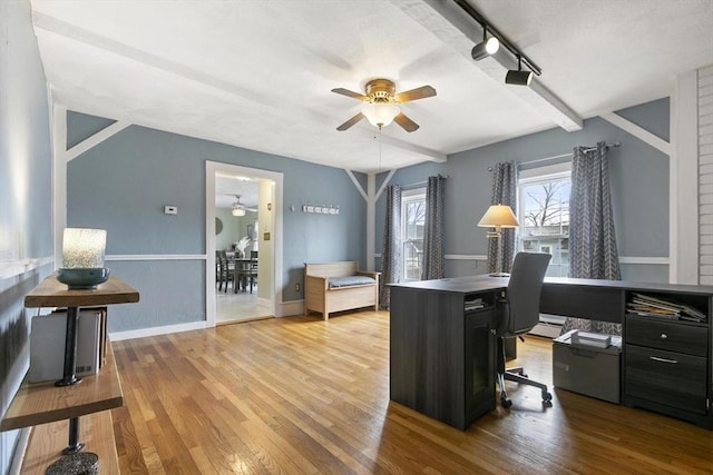 office space featuring ceiling fan, wood finished floors, beam ceiling, and baseboards