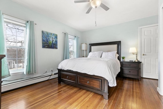 bedroom featuring light wood-style floors, baseboard heating, and a ceiling fan