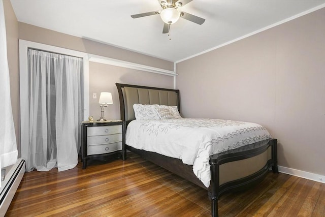 bedroom featuring wood-type flooring, ornamental molding, baseboard heating, and a ceiling fan