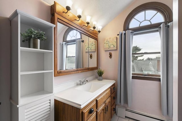 bathroom featuring a baseboard heating unit, lofted ceiling, plenty of natural light, and vanity