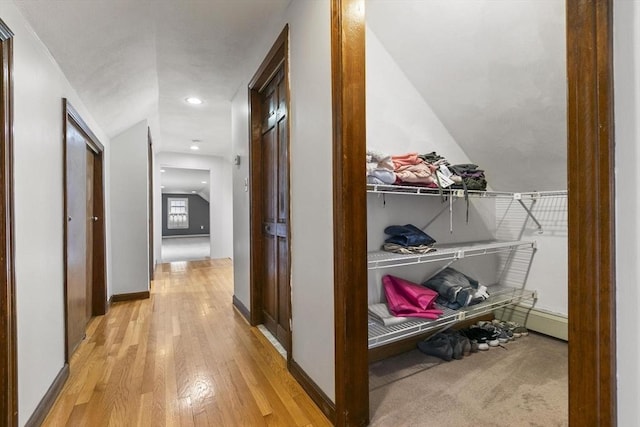 hallway with light wood-type flooring, baseboards, and recessed lighting