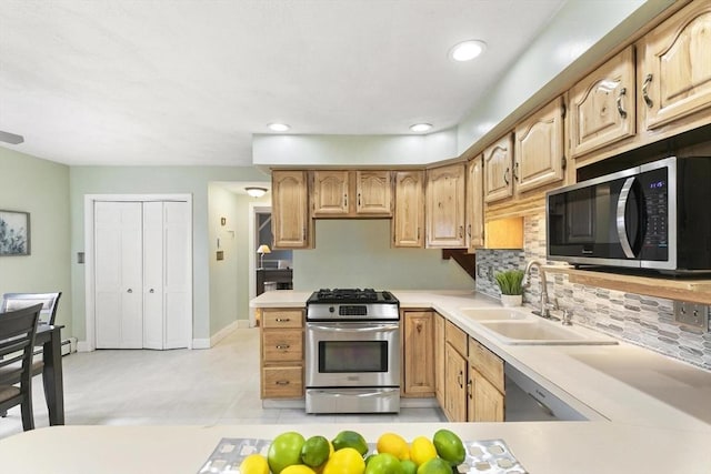 kitchen featuring decorative backsplash, appliances with stainless steel finishes, light countertops, a sink, and recessed lighting