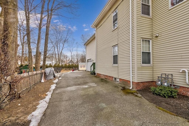 view of home's exterior with driveway and fence