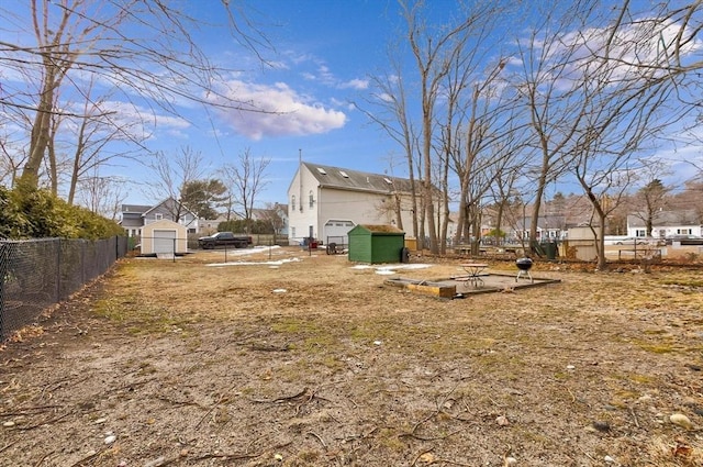 view of yard with an outbuilding, a storage unit, and fence