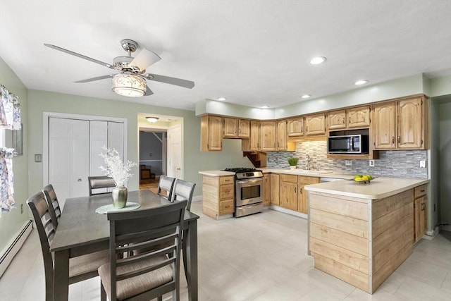 kitchen featuring tasteful backsplash, recessed lighting, light countertops, baseboard heating, and stainless steel gas stove