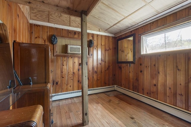 spare room featuring wooden walls, a wall unit AC, hardwood / wood-style flooring, wooden ceiling, and vaulted ceiling
