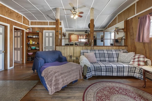 living room with wooden walls, ceiling fan, vaulted ceiling, and wood finished floors
