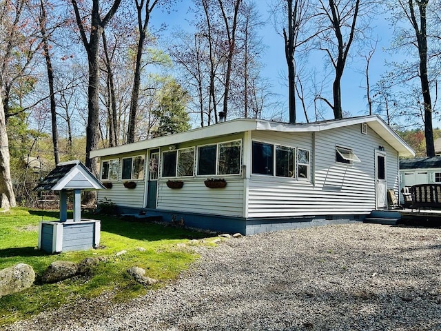 view of front of house featuring a wooden deck, a front lawn, and crawl space