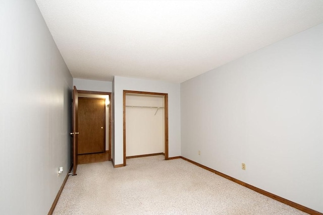 unfurnished bedroom featuring a closet and light carpet