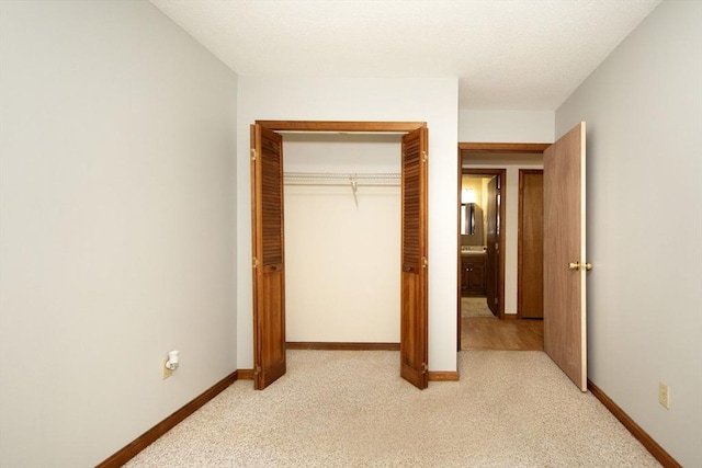 unfurnished bedroom with light carpet and a closet