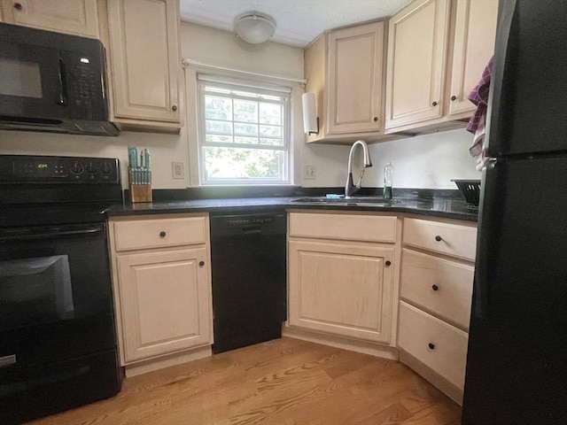 kitchen with light wood-type flooring, sink, and black appliances