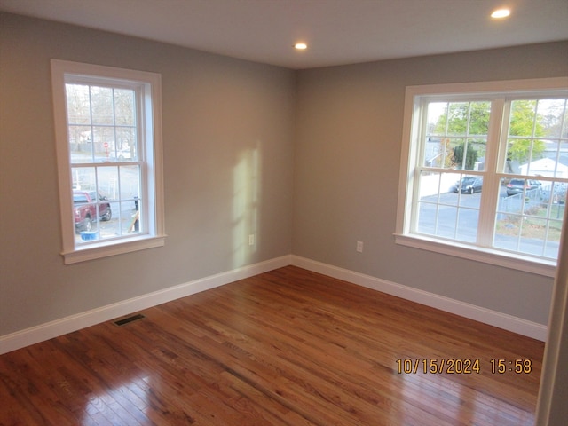 spare room with hardwood / wood-style floors and a healthy amount of sunlight