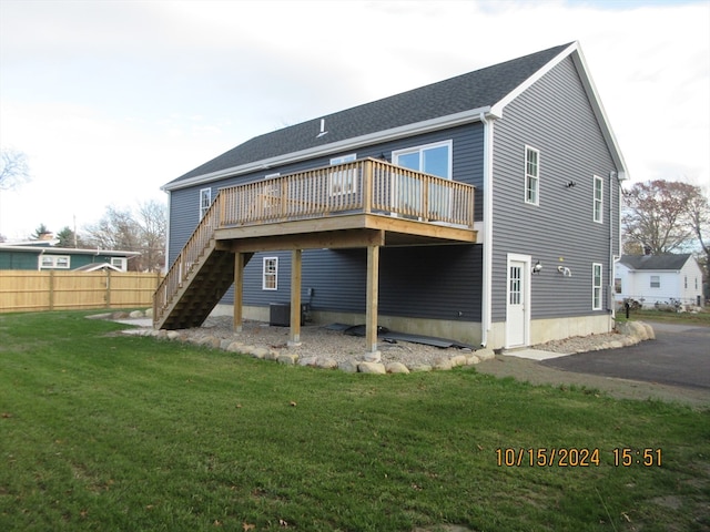 rear view of house with a yard and a deck