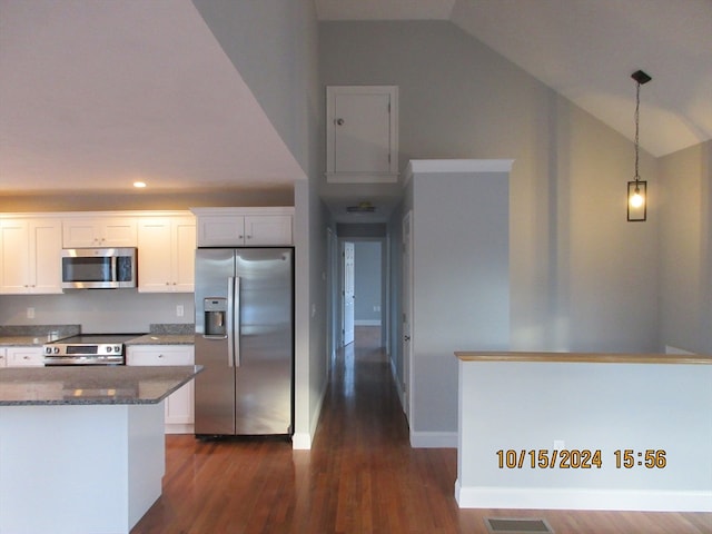 kitchen with appliances with stainless steel finishes, vaulted ceiling, and white cabinetry