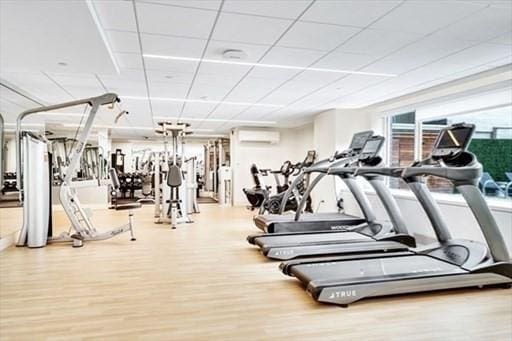 151 Tremont St Unit 9N, Boston, MA 02111 - exercise room featuring an AC wall unit and wood finished floors