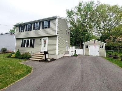15 Northside Ct, Haverhill, MA 01830 - colonial home with an outbuilding, a detached garage, a front lawn, and asphalt driveway