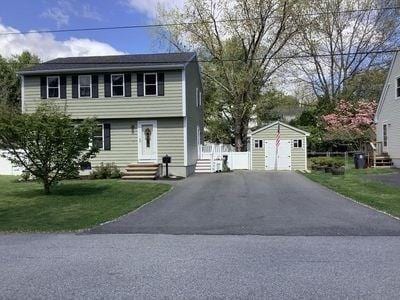 15 Northside Ct, Haverhill, MA 01830 - colonial house with an outdoor structure, a detached garage, asphalt driveway, and a front lawn