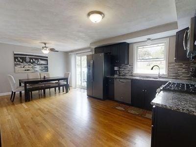 15 Northside Ct, Haverhill, MA 01830 - kitchen featuring stainless steel appliances, dark countertops, tasteful backsplash, wood finished floors, and ceiling fan