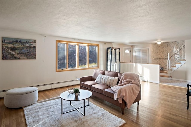 living room with a textured ceiling and light hardwood / wood-style flooring