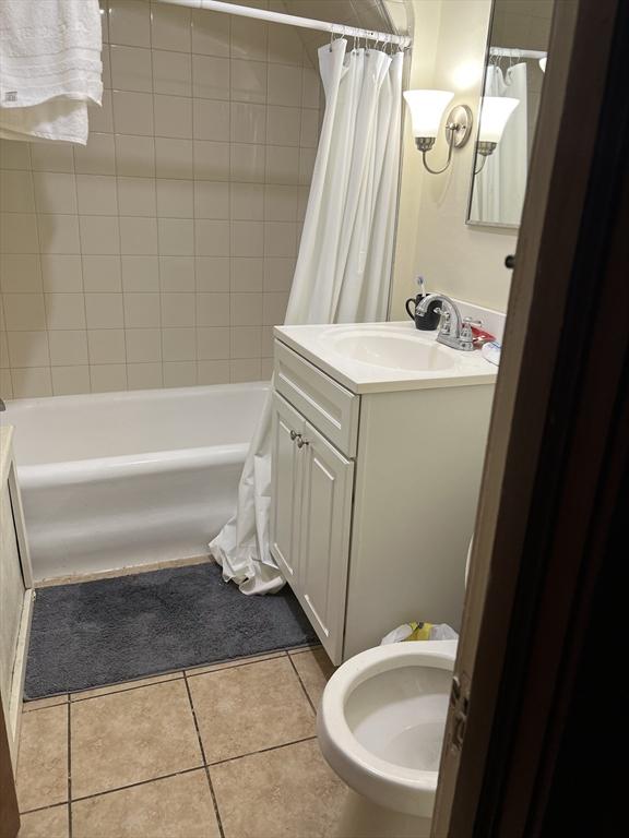 bathroom with tile patterned floors, shower / tub combo with curtain, and vanity