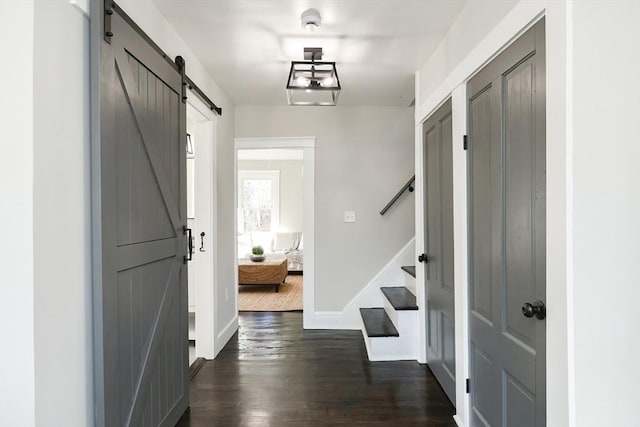 interior space with a barn door and dark wood-type flooring